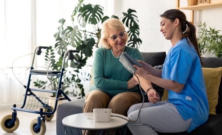 Licensed nurse providing skilled nursing care at home in New Jersey, checking blood pressure of an elderly woman during home health visit.