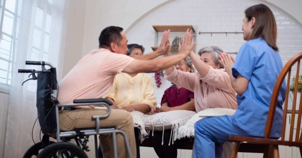 Elderly individuals and a caregiver sharing a joyful moment with high-fives during a home health care session, showing the benefits of home health care for family support.