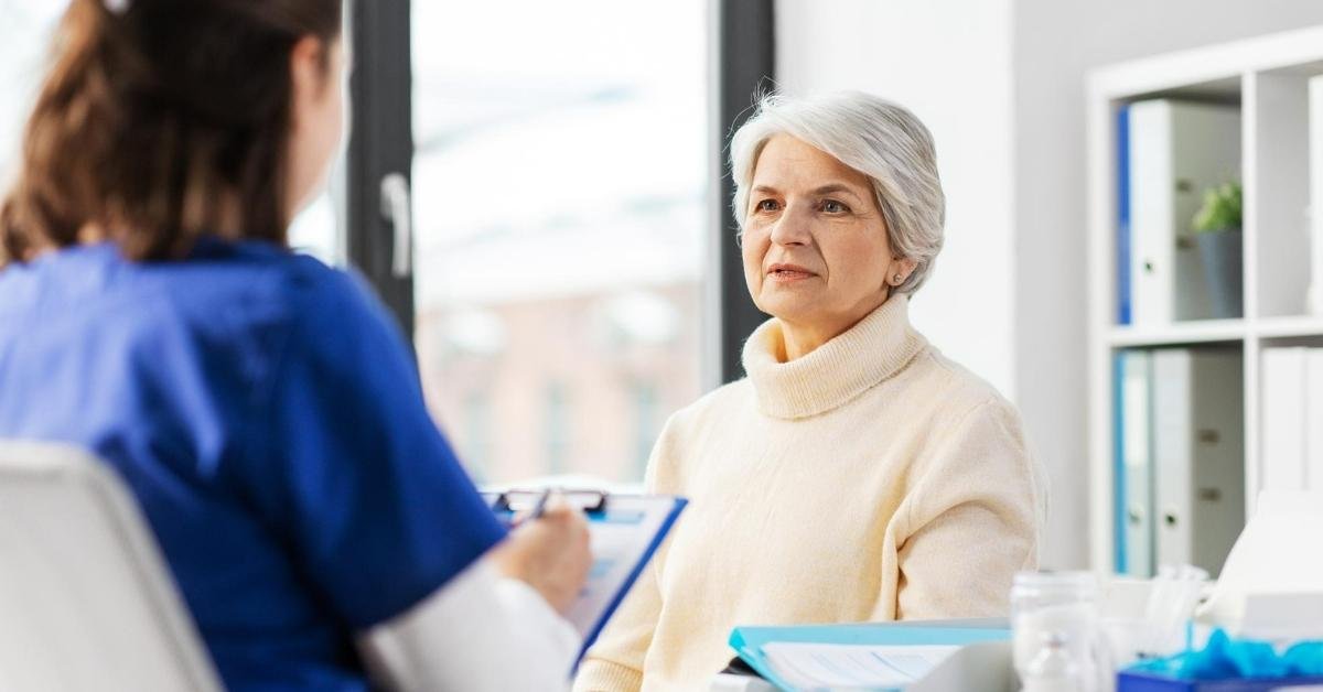 Senior woman receiving consultation from home health nurse, showing the reality behind myths about home health care.