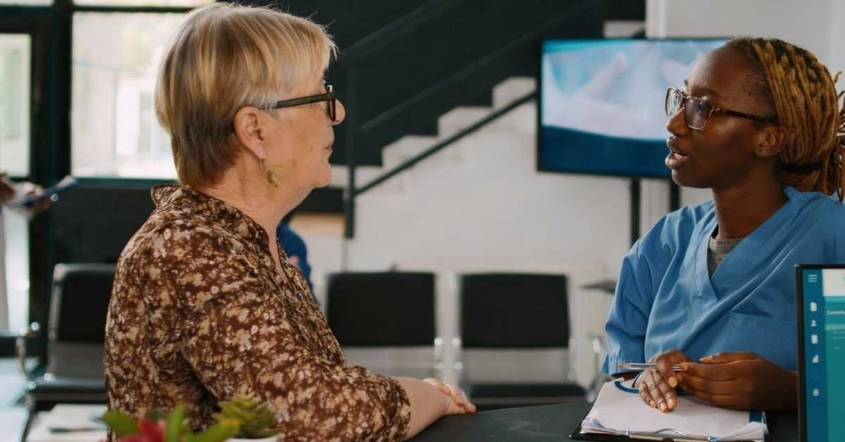 Choosing a caregiver consultation as a professional home care caregiver discusses care options with an elderly woman in a New Jersey home care setting.